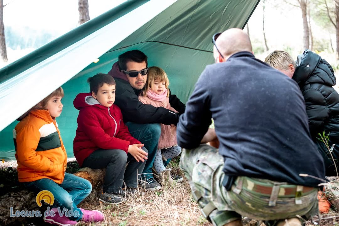 Familia en el bosque aprendiendo habilidades de supervivencia, construyendo un refugio con ramas, encendiendo fuego y purificando agua.